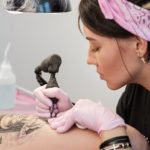 mujer haciendo tatuaje